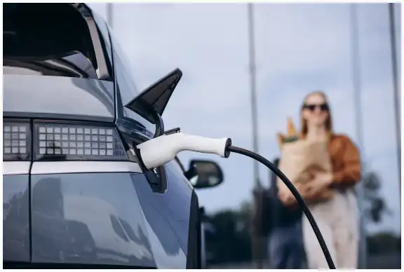 Electric vehicle being charged at a charging station.